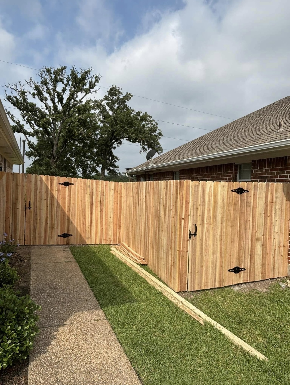Cedar privacy fence with a double drive-through gate along a walkway