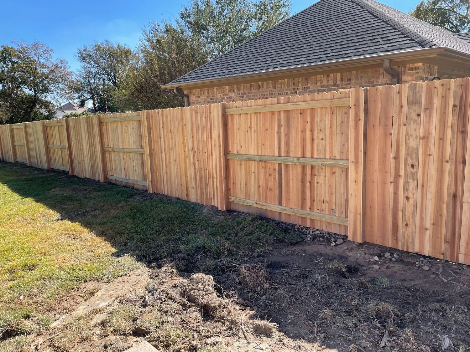 New cedar privacy fence installed along a residential backyard
