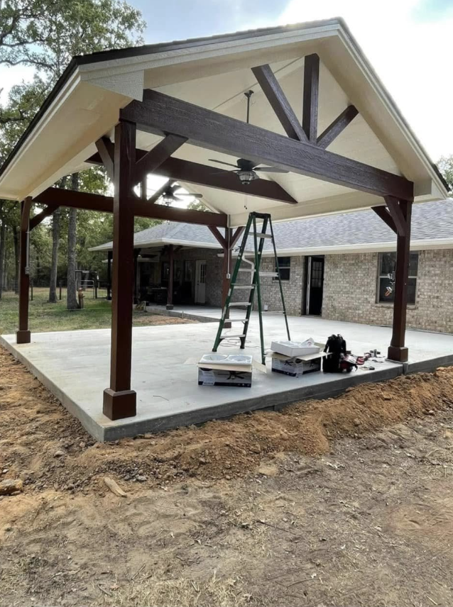 Covered patio with stained wood beams, a vaulted ceiling and ceiling fans