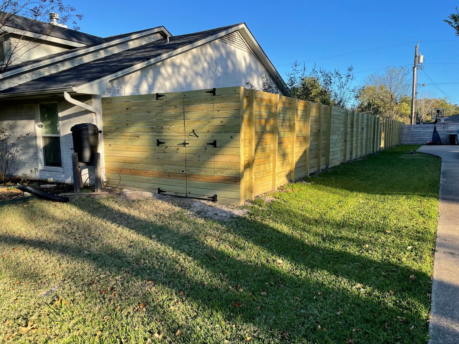 Horizontal wood privacy fence with a wide double gate