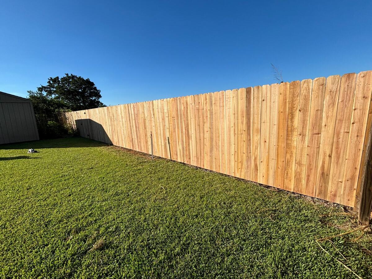 Long run of newly installed wood privacy fencing across a residential backyard