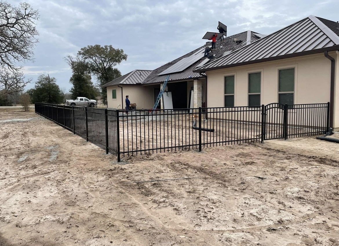 Black ornamental metal fence around a new construction home in the Brazos Valley